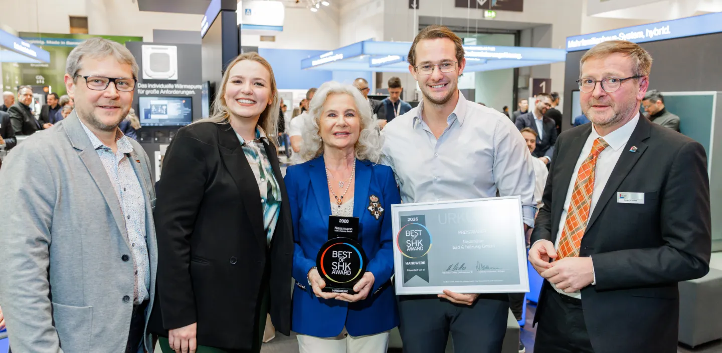 Fünf Personen stehen auf einer SHK-Fachmesse vor einem Buderus-Messestand und präsentieren eine „Best of SHK Award 2026“-Trophäe sowie eine gerahmte Urkunde.