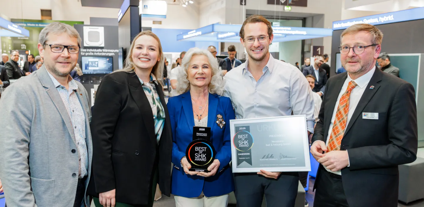 Fünf Personen stehen auf einer SHK-Fachmesse vor einem Buderus-Messestand und präsentieren eine „Best of SHK Award 2026“-Trophäe sowie eine gerahmte Urkunde.