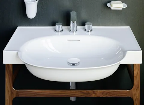 Geschwungener Waschtisch der Serie New Classic von Laufen auf einem Holzgestell.