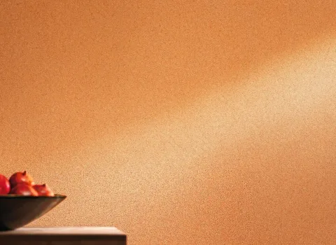 Eine stilvolle Innenraumgestaltung mit Wänden, die mit Lehm-Kalk-Putz versehen sind. Die Struktur des Putzes verleiht der Wand eine natürliche und elegante Optik. Der Raum wirkt hell und einladend, und die Textur des Putzes trägt zu einem gesunden Raumklima bei, indem sie die Feuchtigkeit reguliert. Im Vordergrund des Bildes sind keine weiteren Möbel oder Dekorationen sichtbar, sodass die Wandstruktur im Mittelpunkt steht.