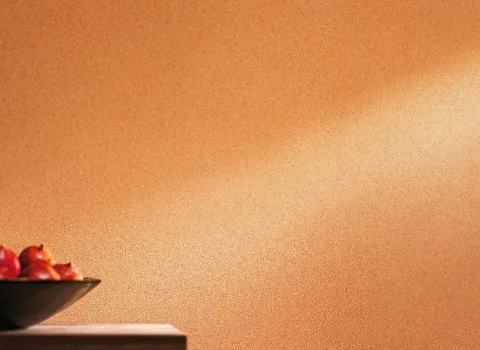 Eine stilvolle Innenraumgestaltung mit Wänden, die mit Lehm-Kalk-Putz versehen sind. Die Struktur des Putzes verleiht der Wand eine natürliche und elegante Optik. Der Raum wirkt hell und einladend, und die Textur des Putzes trägt zu einem gesunden Raumklima bei, indem sie die Feuchtigkeit reguliert. Im Vordergrund des Bildes sind keine weiteren Möbel oder Dekorationen sichtbar, sodass die Wandstruktur im Mittelpunkt steht.