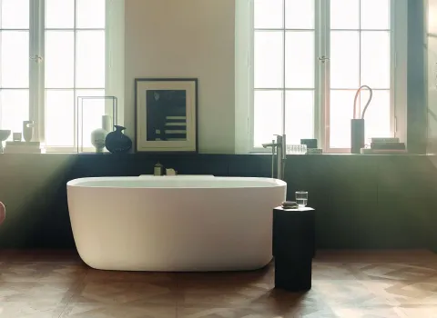 Elegantes Badezimmer mit freistehender Badewanne, großen Fenstern und stilvollen Accessoires wie Vasen und Büchern.