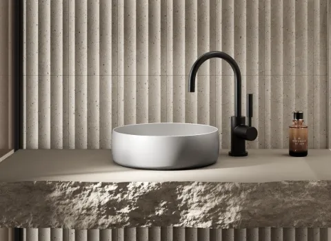 Waschbecken BetteLiv auf hellen Natursteinwaschtisch mit schwarzer Armatur