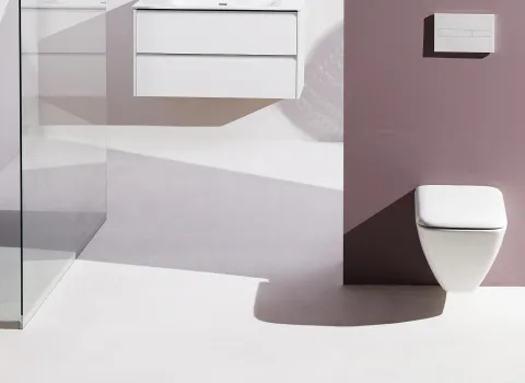 Badezimmer mit wandhängendem WC an lila Wand, links eine Glasdusche, modernes und offenes Design.