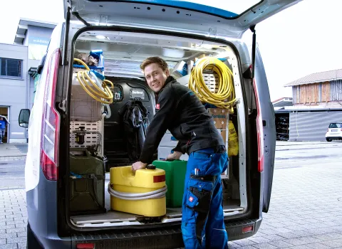 Kundendiensttechniker (SHK) vor Service-Fahrzeug.