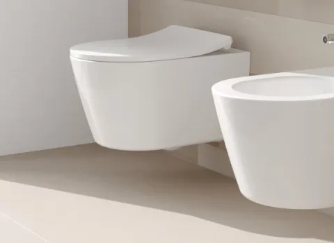 Ein modernes Badezimmer mit einer hängenden Toilette und einem daneben platzierten wandmontierten Bidet. 
