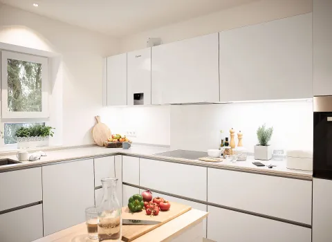 Helle Küche mit Einbau-Gasbrennwertgerät von Vaillant in den Oberschränken.