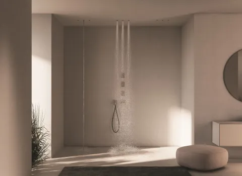 In einem modernen Wellness-Badezimmer ist eine Frattini Waterdot Duschsystem installiert, das vier vertikale Wasserstrahlen gleichmäßig nach unten fließen lässt.