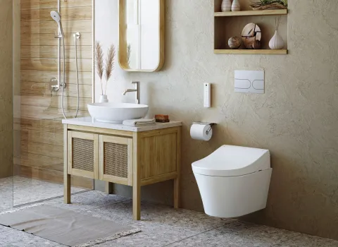 Ein modernes Badezimmer zeigt ein wandhängendes TOTO Washlet RG neben einem Holzwaschtisch mit Aufsatzwaschbecken.