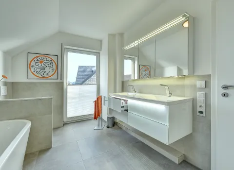 Helles Bad mit Doppelwaschtisch, großem Spiegelschrank und klarer Linienführung, umgesetzt durch die Nessmann Bad & Heizung GmbH.