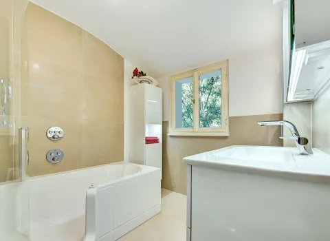 Detailansicht der Badewanne mit Glasabtrennung, Regendusche und Thermostatarmaturen, realisiert durch die Nessmann Bad & Heizung GmbH.