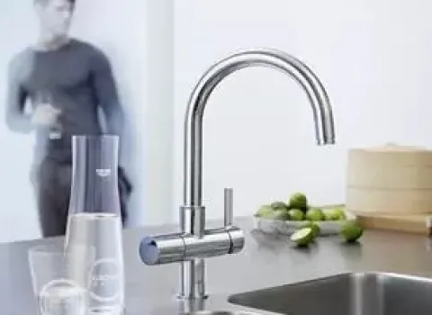 Moderne Küchenarmatur mit integriertem Trinkwassersystem Grohe Blue für gefiltertes und gekühltes Wasser in einer Designküche.
