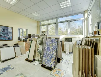 Ein heller Ausstellungsraum mit einer großen Auswahl an Fliesen in verschiedenen Farben, Mustern und Materialien in Düsseldorf, präsentiert von Nessmann bad & heizung GmbH.