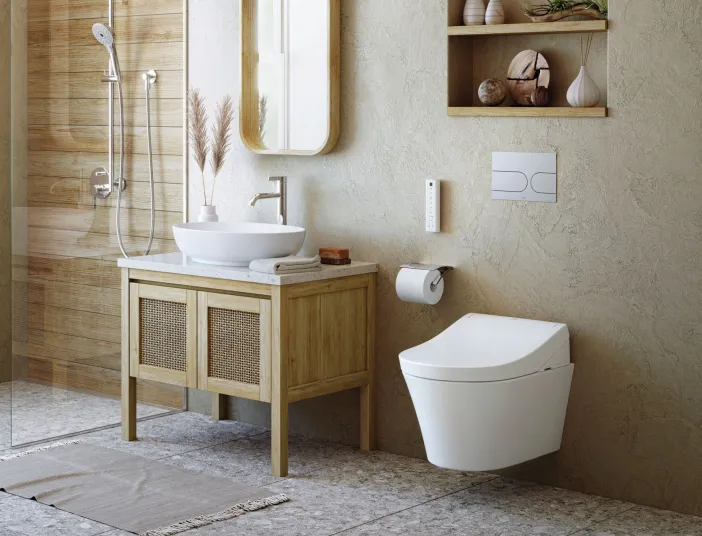 Ein modernes Badezimmer zeigt ein wandhängendes TOTO Washlet RG neben einem Holzwaschtisch mit Aufsatzwaschbecken.