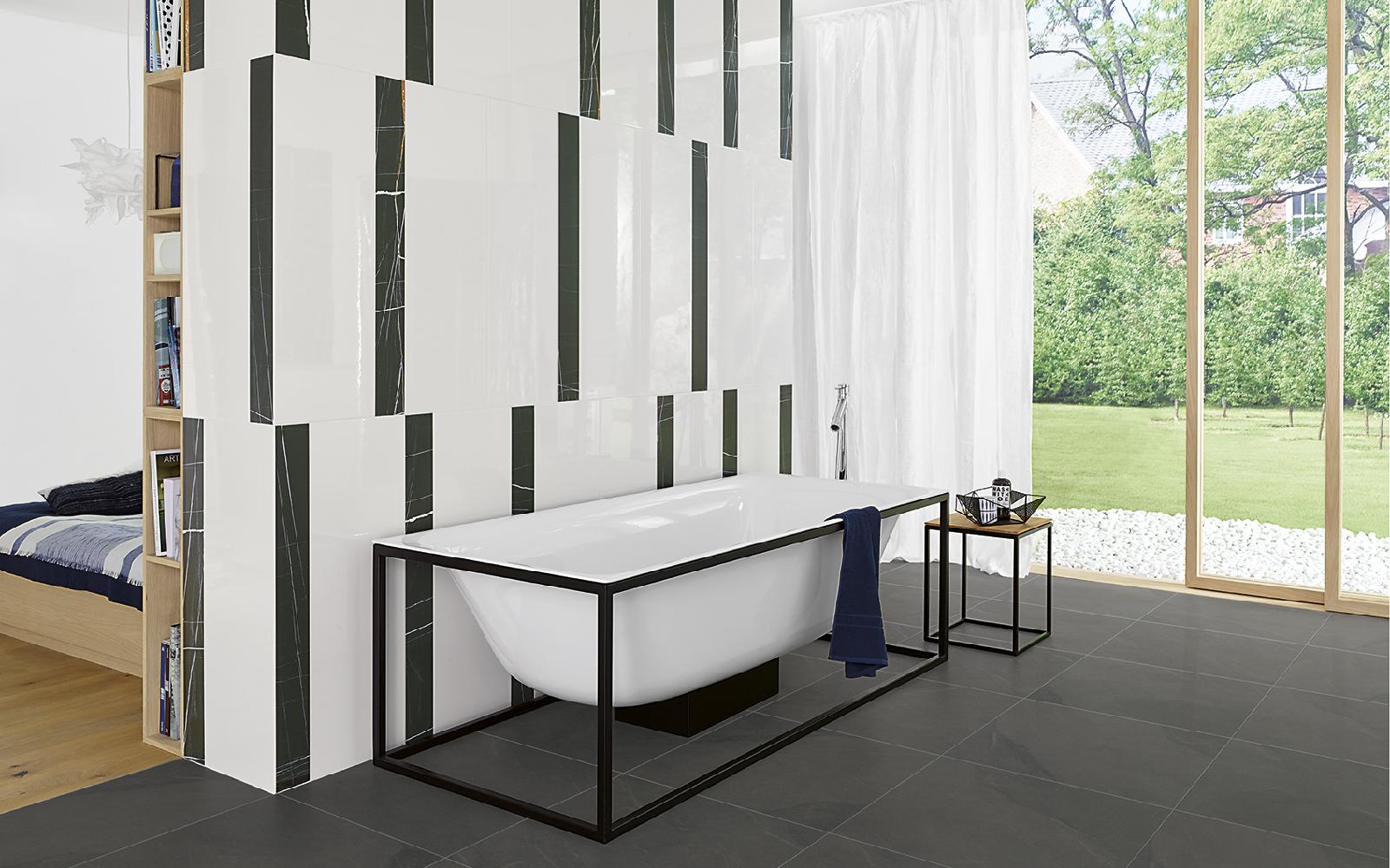 Badewanne vor einer schwarz-weiß gefliesten Wand